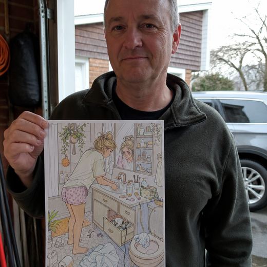 Real Journey Engine customer holding a page they hand-coloured